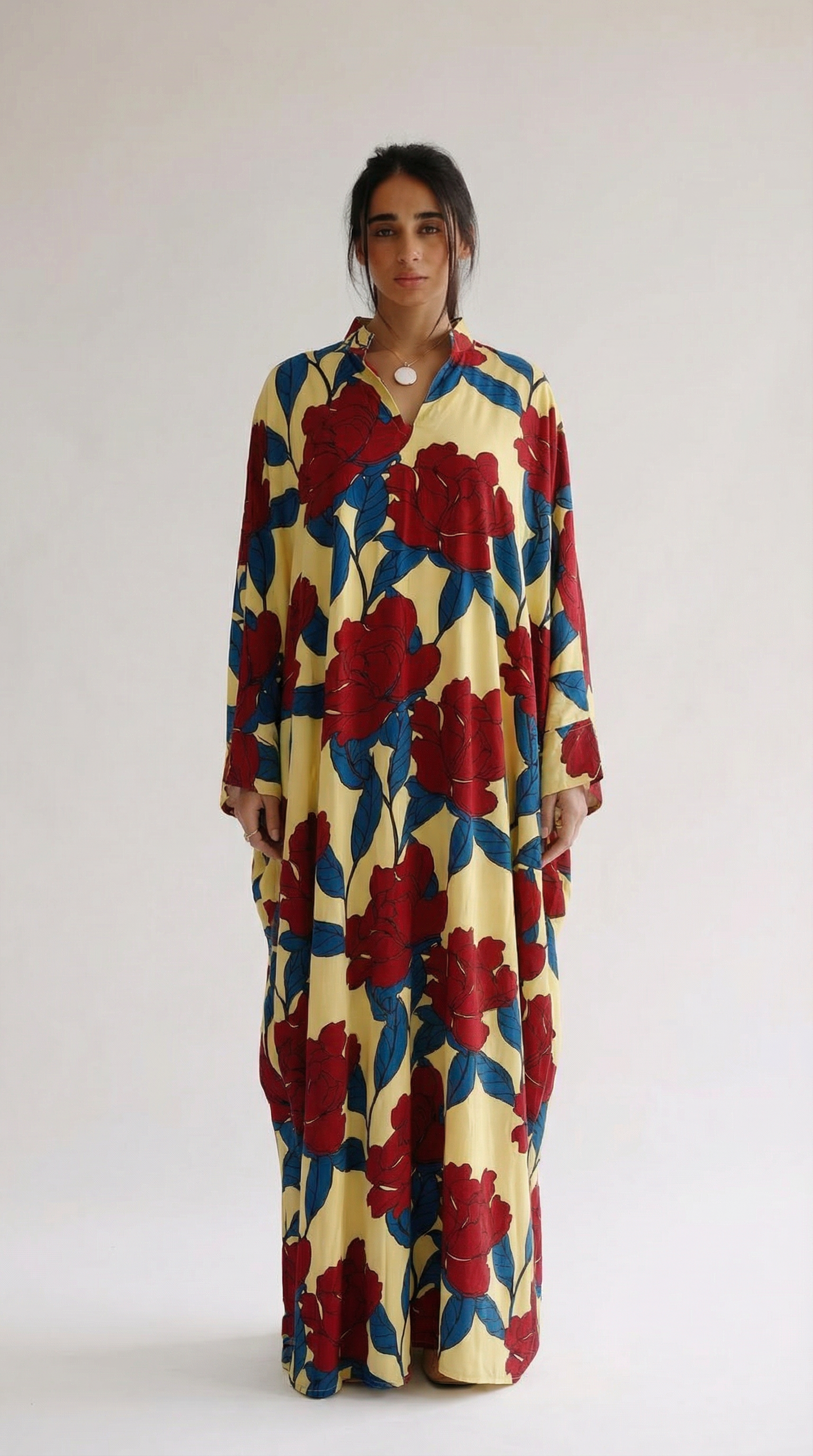 Woman wearing a colorful floral dress against a white background