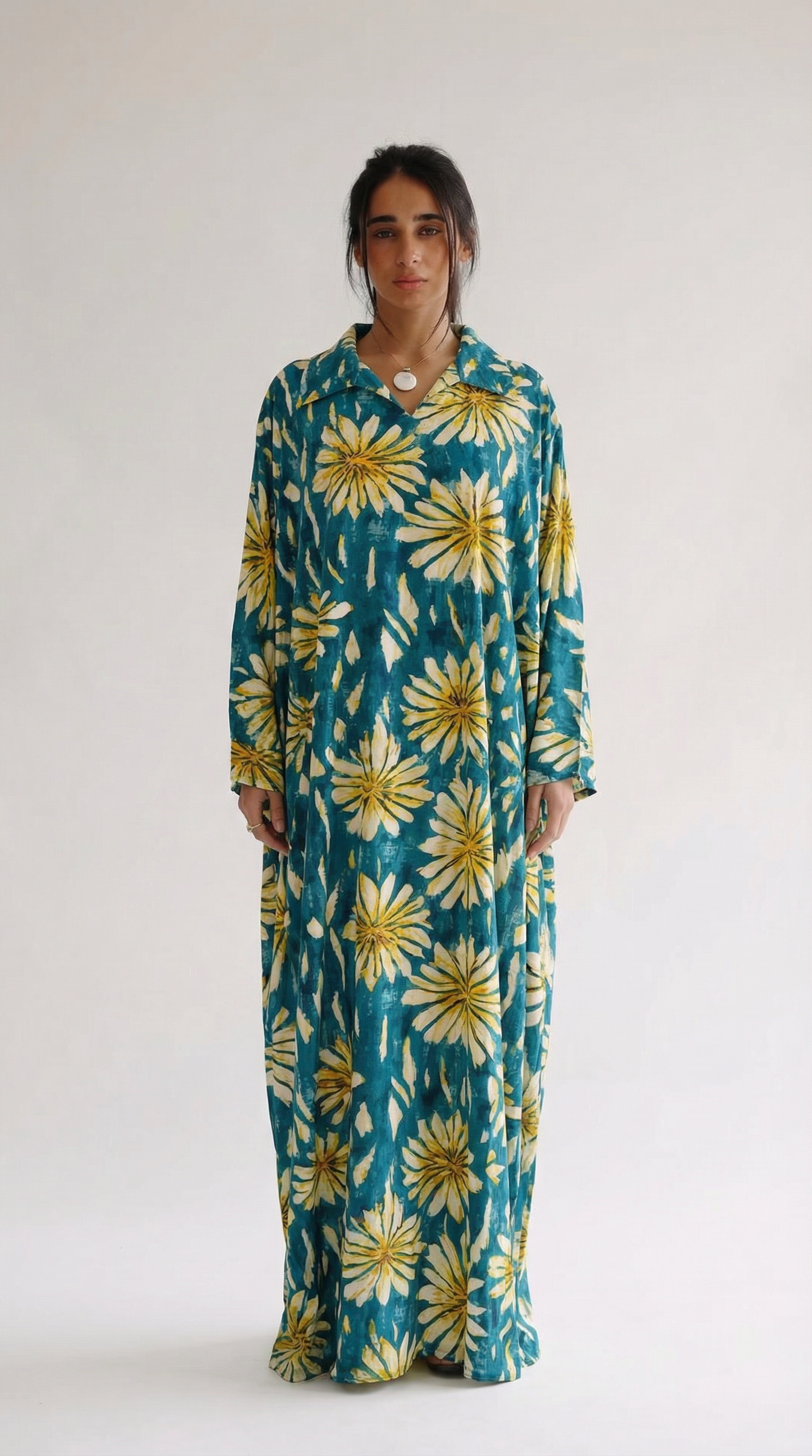Woman wearing a long floral dress with a white background