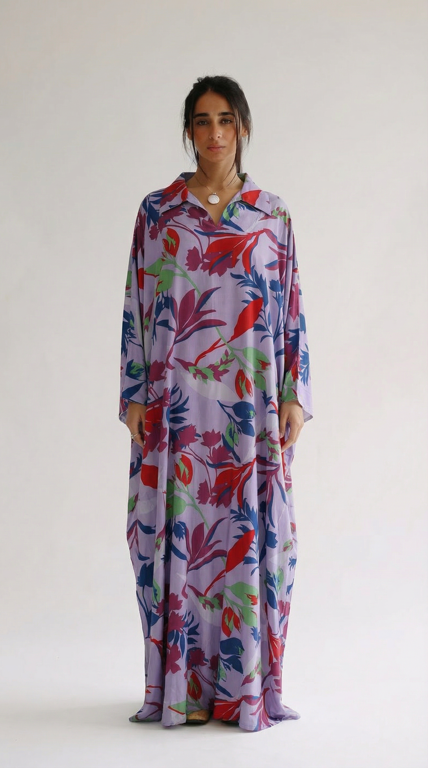 Woman wearing a colorful floral dress on a white background