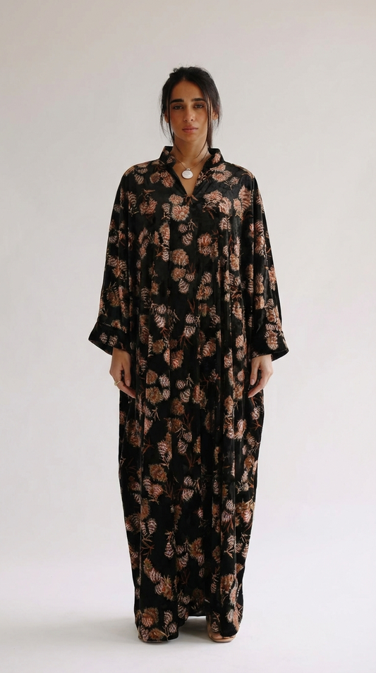 Woman wearing a black floral dress against a white background