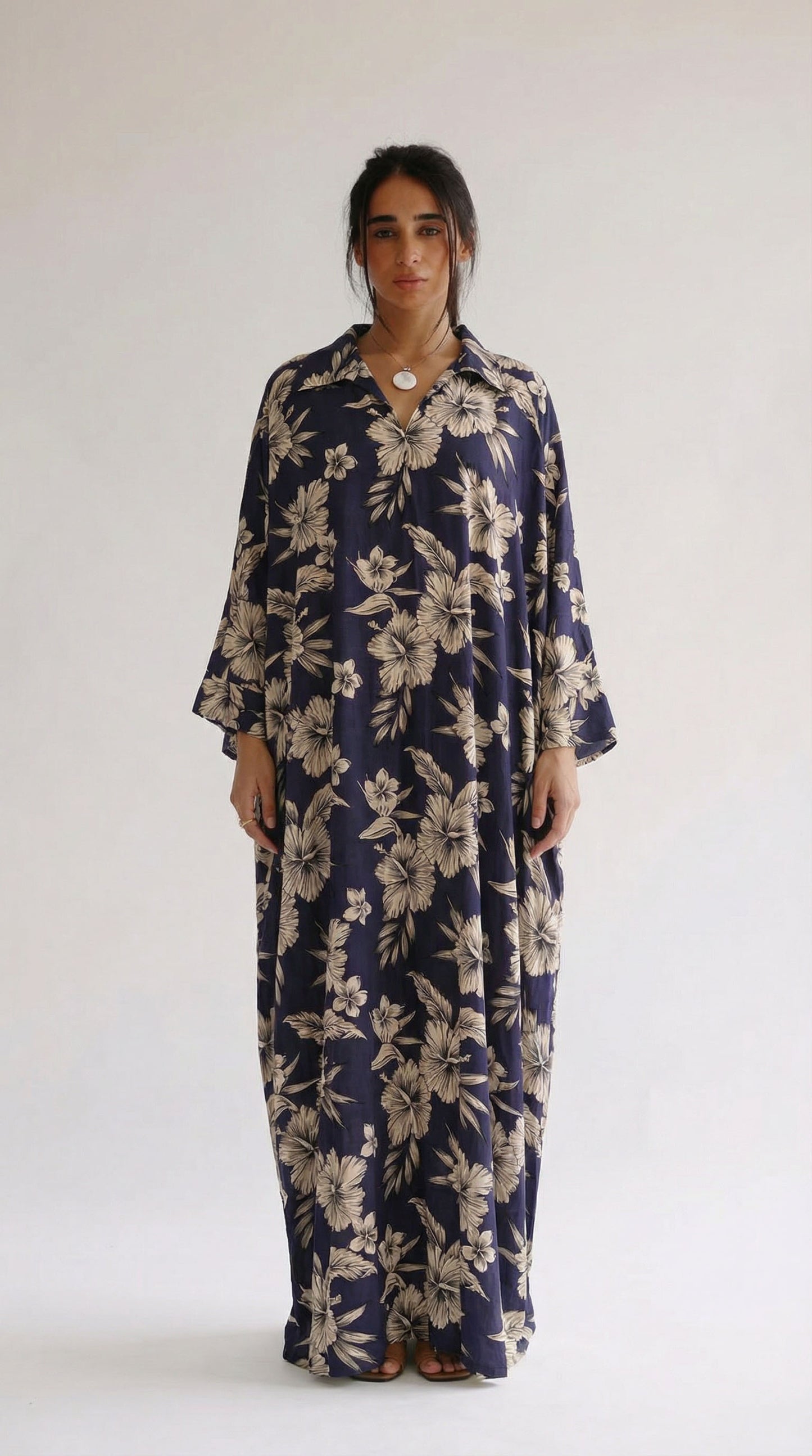 Woman wearing a navy floral dress against a white background