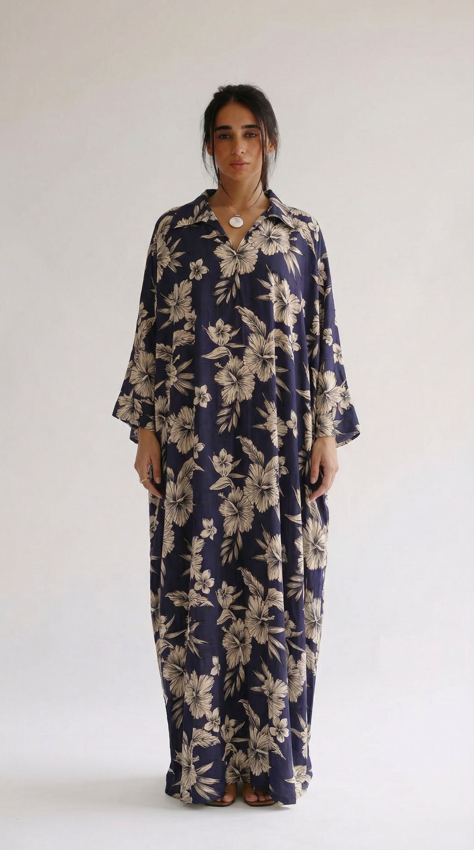 Woman wearing a navy floral dress against a white background
