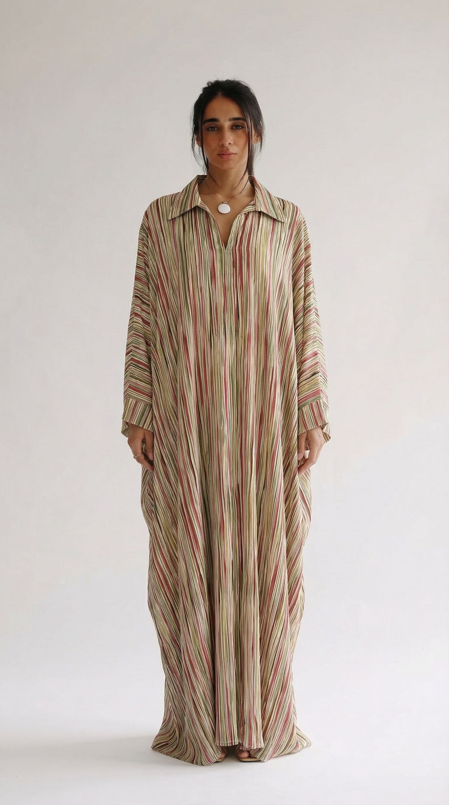 Woman wearing a long, striped dress against a white background