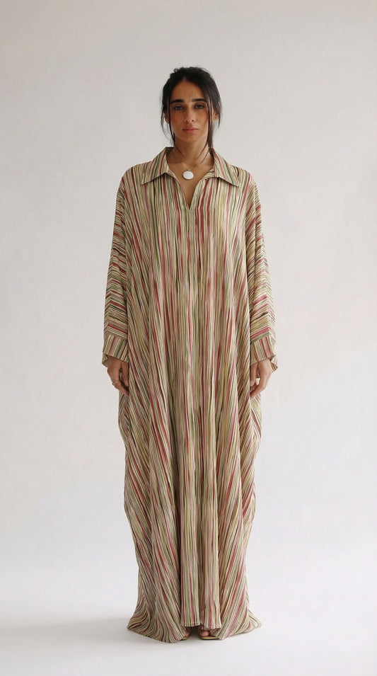 Woman wearing a long, striped dress against a white background