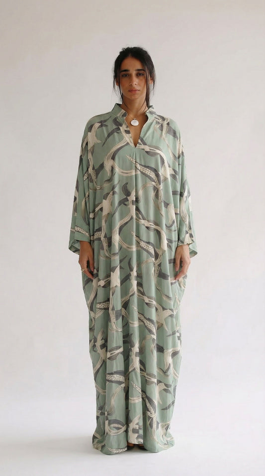 Woman wearing a long, patterned dress against a white background