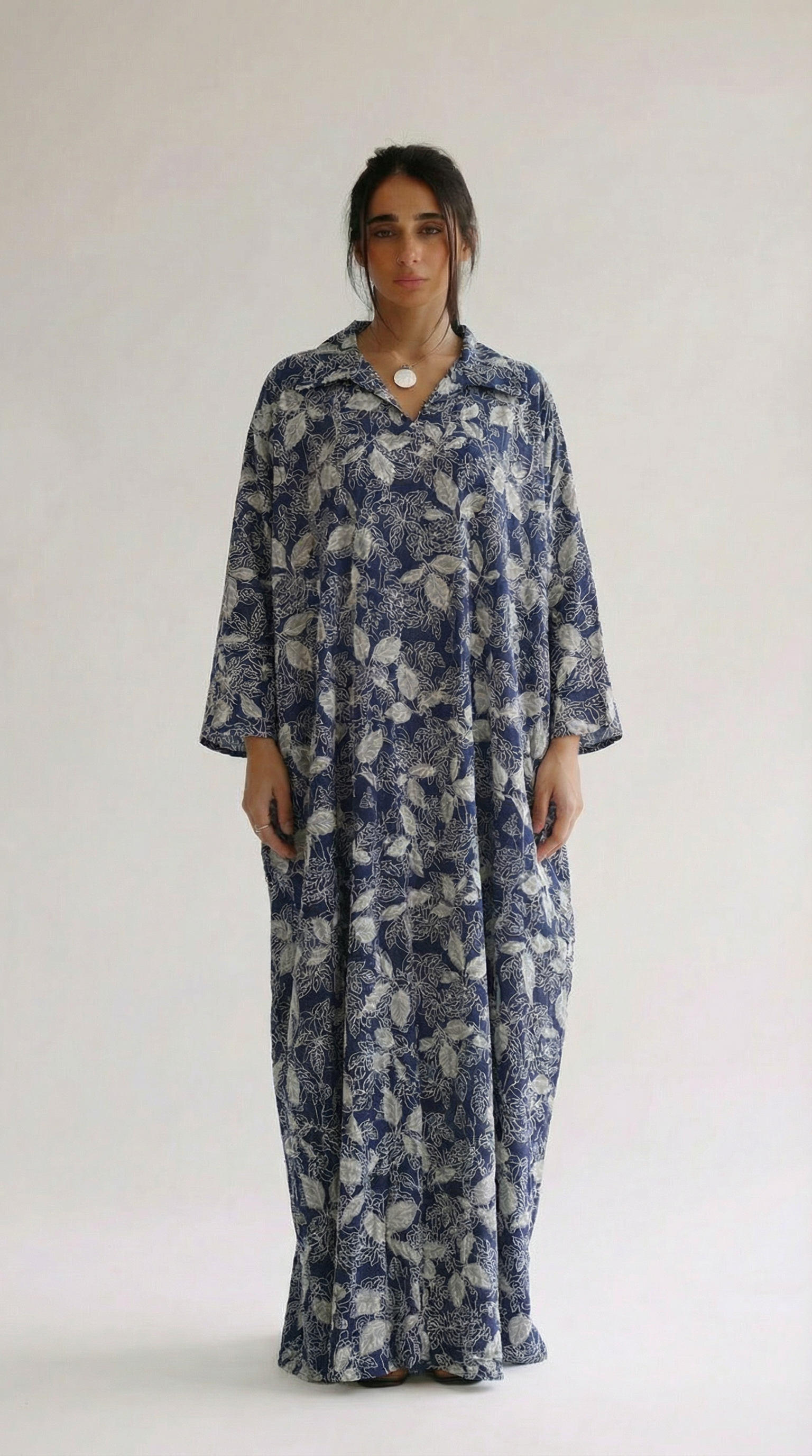 Woman wearing a blue floral dress against a white background