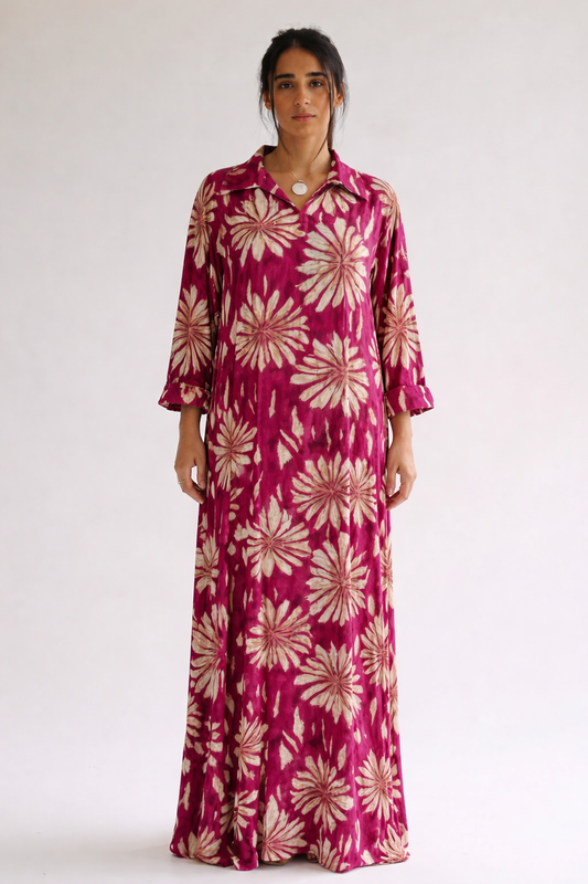 Woman wearing a long, floral-patterned dress against a white background