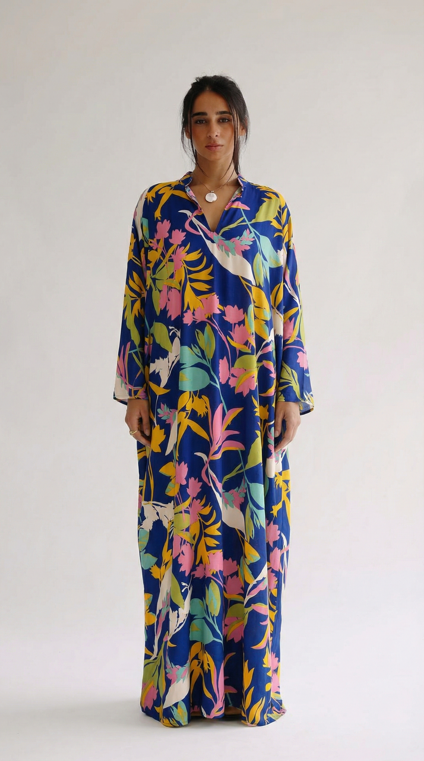 Woman wearing a colorful floral dress on a white background