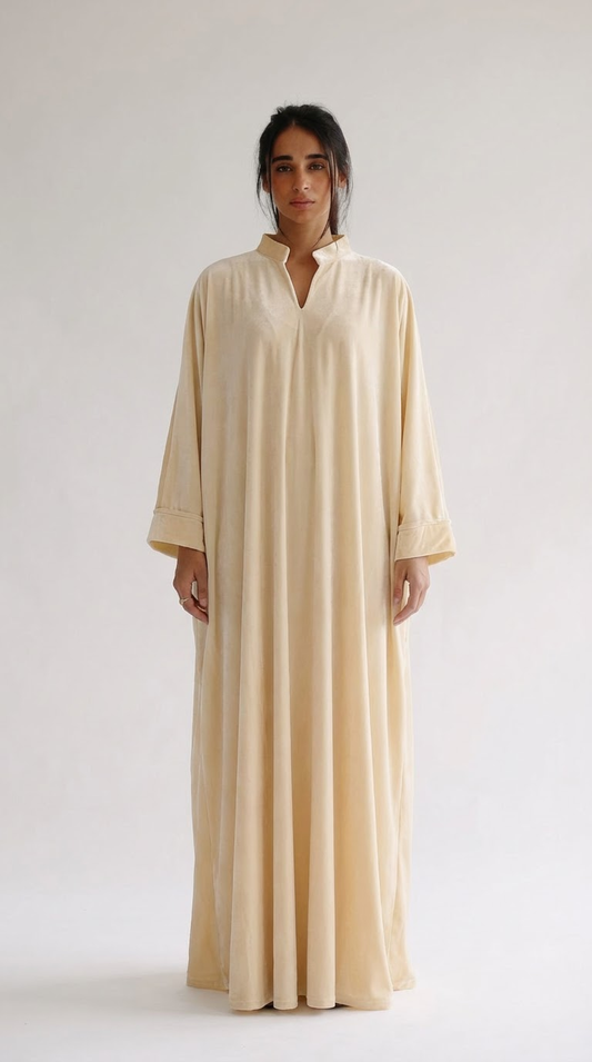 Woman wearing a beige long dress against a white background