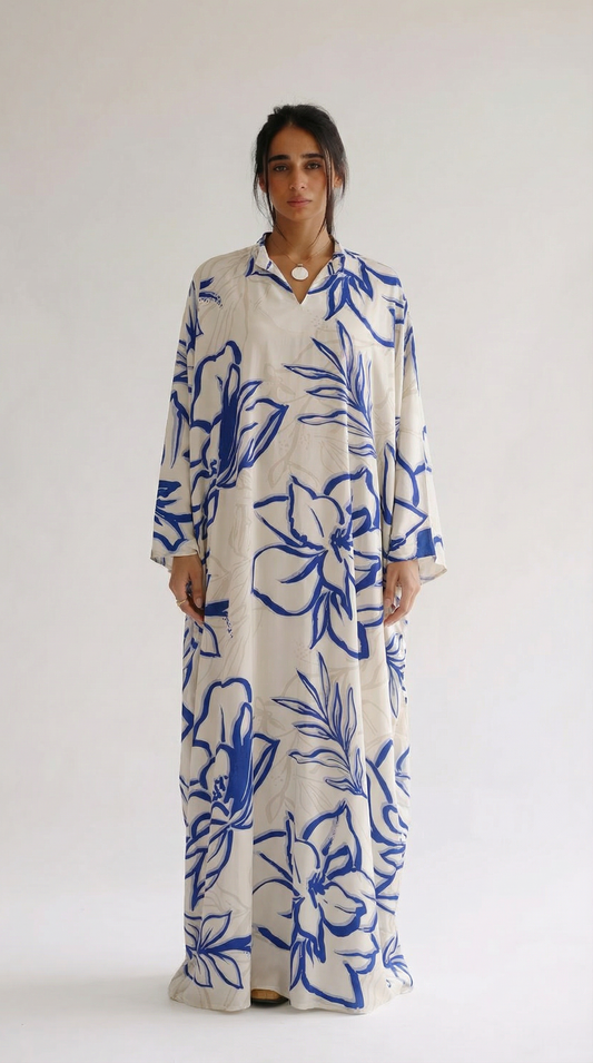 Woman wearing a long floral dress with blue and white pattern on a plain background