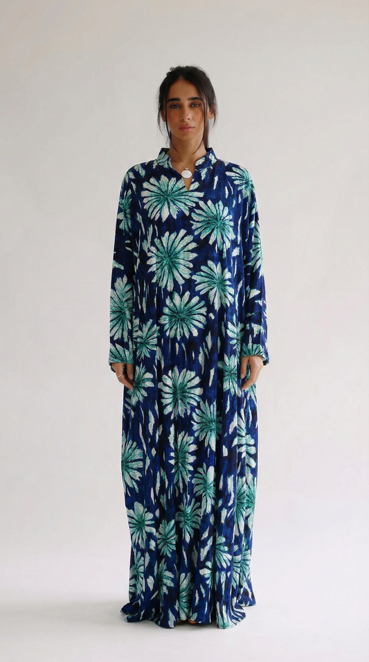 Woman wearing a long blue floral dress on a white background