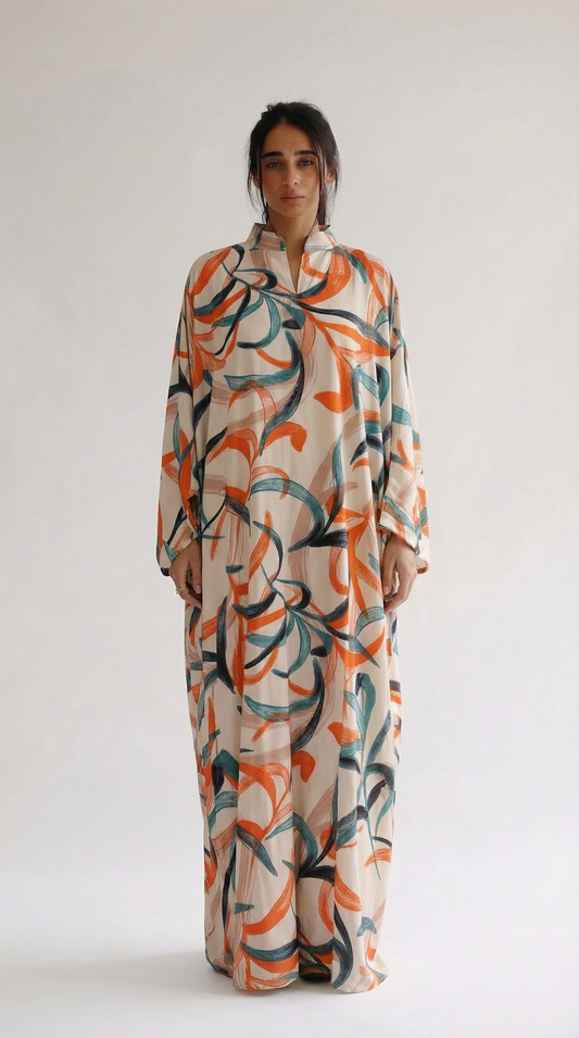 Woman wearing a long, patterned dress against a white background