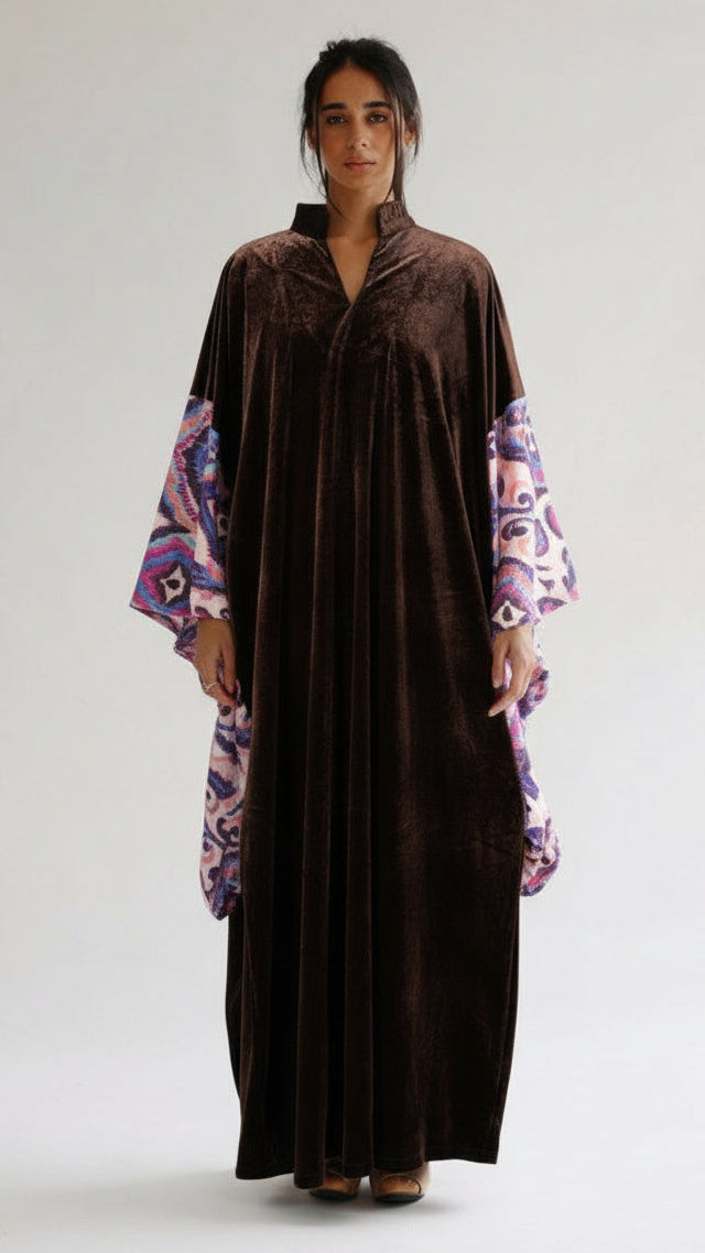 Woman wearing a brown dress with floral sleeves on a white background