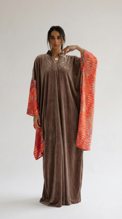 Woman wearing a brown dress with red sleeves against a white background