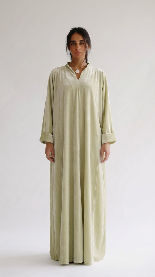 Woman wearing a long, light-colored dress against a white background